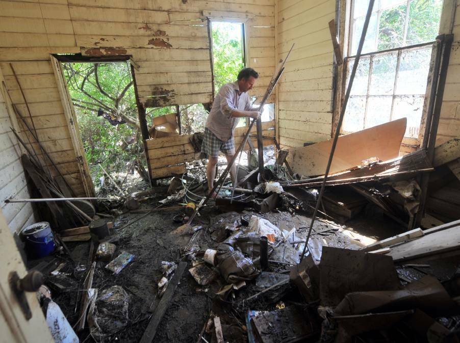 Daniel Burgemeister helps clean up Julienne Brettle's home after the Carisbrook floods of 2011. Picture: BRENDAN MCCARTHY