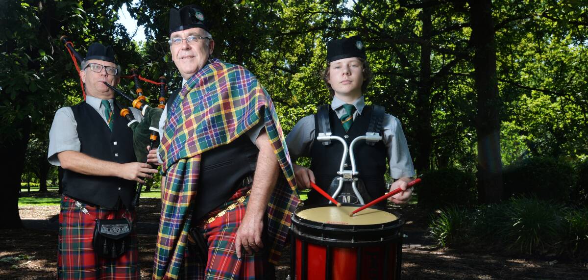 CHECK: Chris Earl (centre) and members of the Golden City Pipe Band unveil Bendigo's official tartan in Rosalind Park. Picture: DARREN HOWE