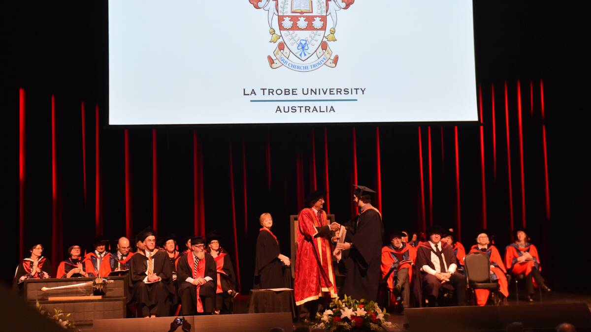 PROUD MOMENT: La Trobe graduates ascend the stage at Ulumbarra to collect their graduation diploma. Picture: DARREN HOWE
