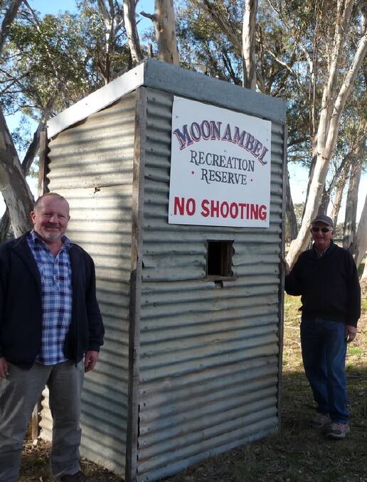 HISTORIC: A cheery picture of MAHG members Garry and Ray displaying their work. It’s been modified since, by two gaping holes from shotgun blasts on both sides.