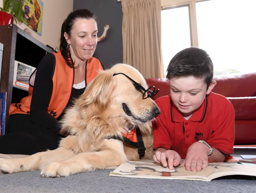 GOOD LISTENER: Jacqui MacMillan and Honey the Story Dog listen to Cooper read in 2020. Picture: Lachlan Bence