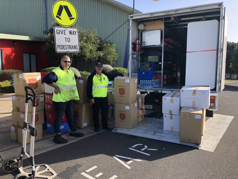Salvation Army volunteer Scott Collins and regional coordinator for emergency services Darren White unload a truck full of supplies that was driven in overnight from Ballarat.