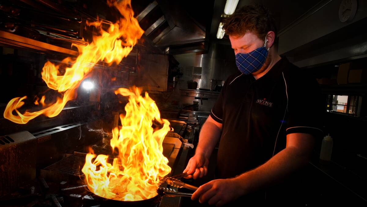 FLAMING GOOD: National Hotel chef Patrick McCallum was one of the chefs busy cooking dozens of meals as part of the Cafes for COVID program. Picture: NONI HYETT. 