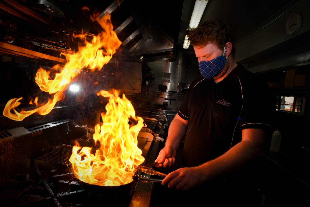 FLAMING GOOD: National Hotel chef Patrick McCallum is one of the chefs who have been busy cooking dozens of meals as part of the Cafes for COVID program. Picture: NONI HYETT. 