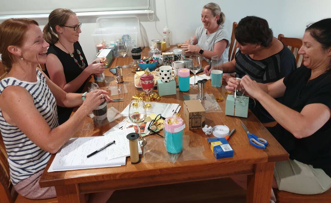 Liz Foster, Vicki Lane, Mel Wilkie, Maria Tzaros and Simone Fordham wrap donated cups for Corryong residents impacted by bushfires. 