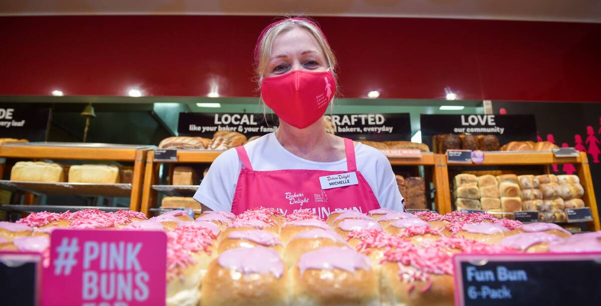 YUM: Bakers Delight Bendigo Marketplace's Michelle Luton serving up dozens of pink buns to support BCNA's fundraiser. Picture: DARREN HOWE