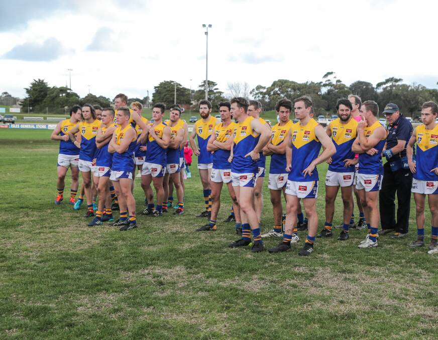 Disappointed: Bendigo league players stand on a patchy Reid Oval surface after their nine-point loss to Hampden on Saturday. Picture: Reid Oval