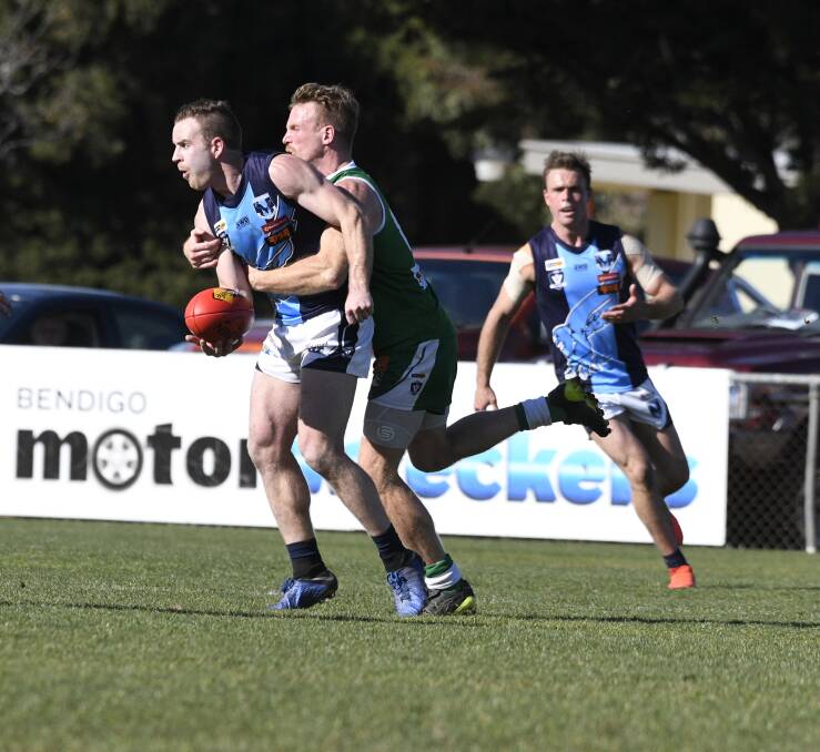 TACKLE PRESSURE: Eaglehawk's Ben McPhee tries to get a handball clear despite the attention of Kangaroo Flat's Ross Turner. Pictures: NONI HYETT