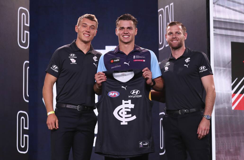 Brodie Kemp is presented with a Carlton jumper by Patty Cripps and Sam Docherty. Picture: GETTY IMAGES