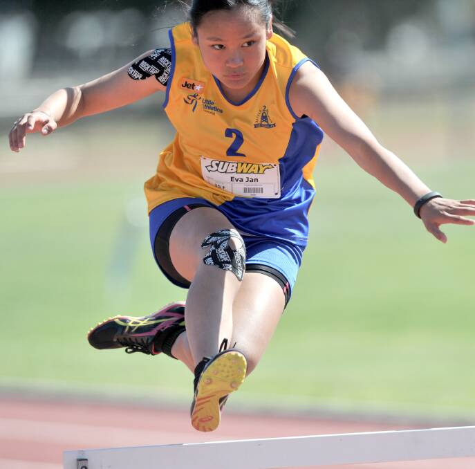 UP AND OVER: Jan Eva clears the hurdle in fine style at Little Athletics. Picture: NONI HYETT