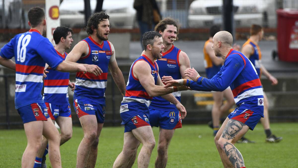 HAPPY DOGS: Gisborne players congratulate Scott Walsh on a goal in the second quarter of the first semi-final.