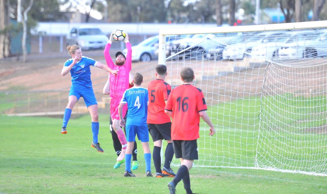 Strathdale's Jack Kelly challenges the Shepparton keeper for the ball.
