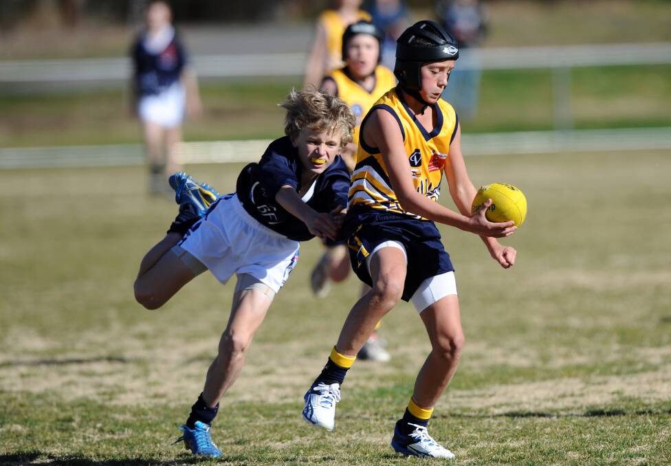 Jye Caldwell fires out a hanbdall for the BJFL under-12s against Ballarat in 2012.