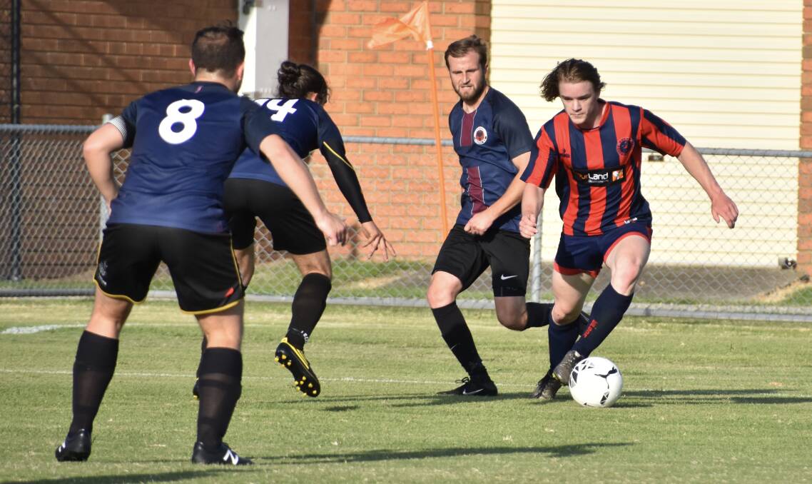 THREE ON ONE: Epsom young gun Adam Dwyer cuts inside the Dandenong South defence in Saturday's FFA Cup clash in Melbourne. 
