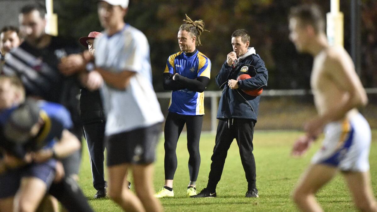 Golden Square captain Jack Geary and coach Chris Carte watch the Dogs go through their paces. Picture: NONI HYETT