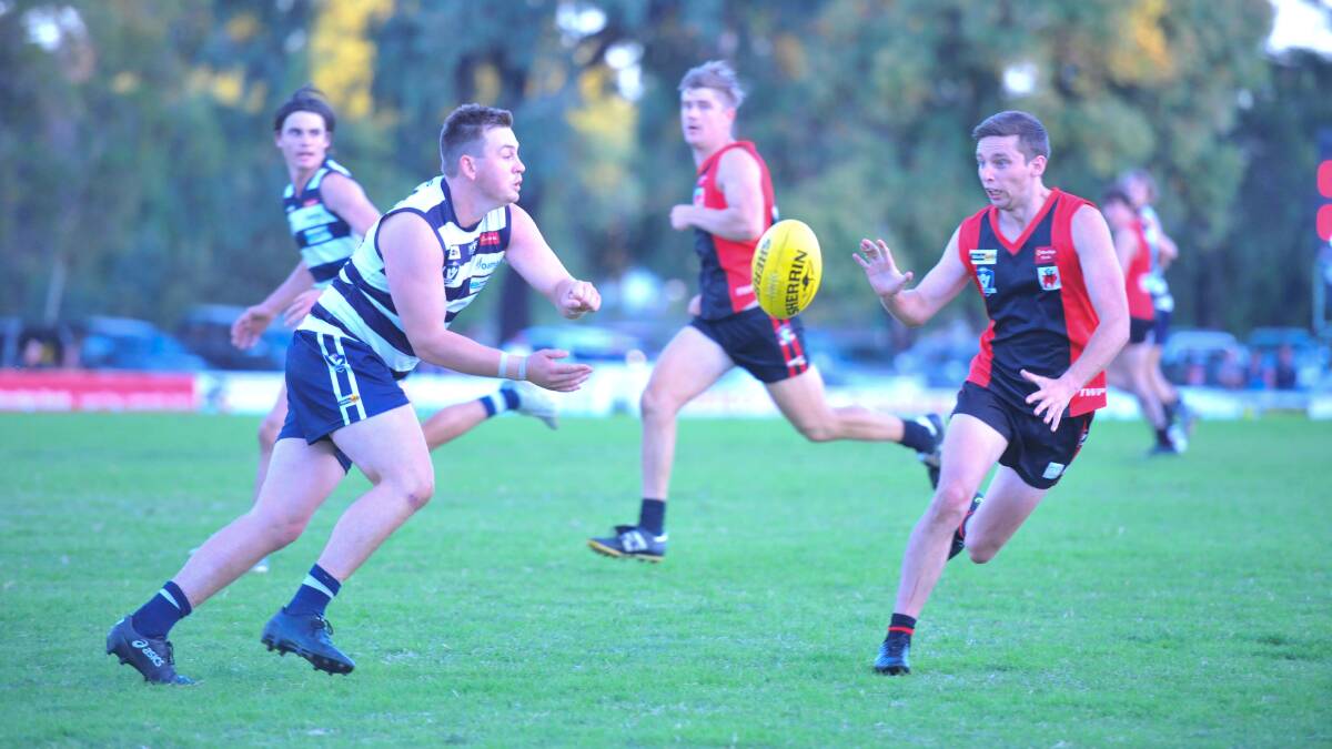 LBU star Lachlan Collins fires out a handball ahead of White Hills' Rhys Irwin. Picture: ADAM BOURKE