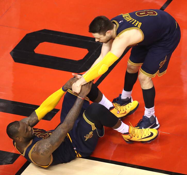 DOWN, BUT NOT OUT: Matthew Dellavedova helps LeBron James to his feet during game four of the NBA eastern conference finals. Picture: GETTY