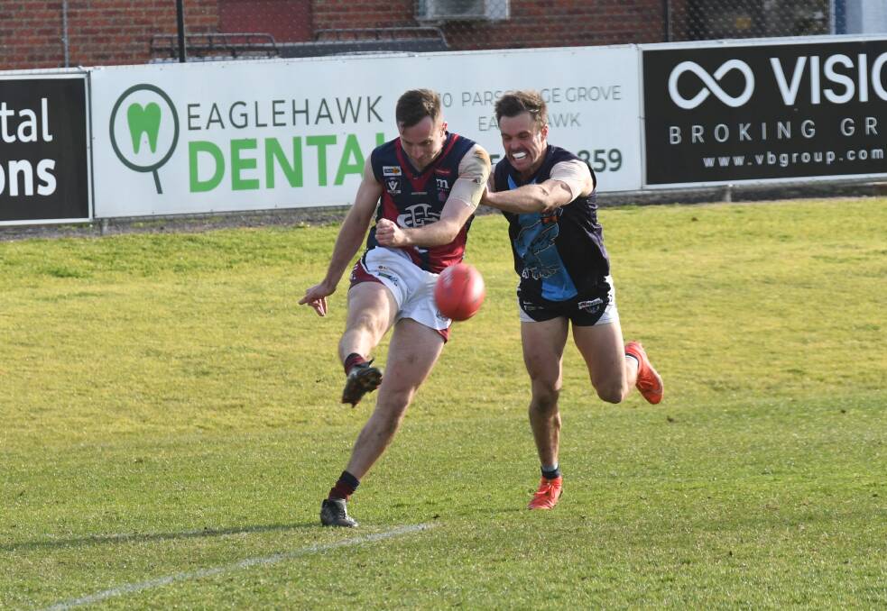 Jake McLean gets a kick away ahead of Sam Thompson. Picture: ANTHONY PINDA