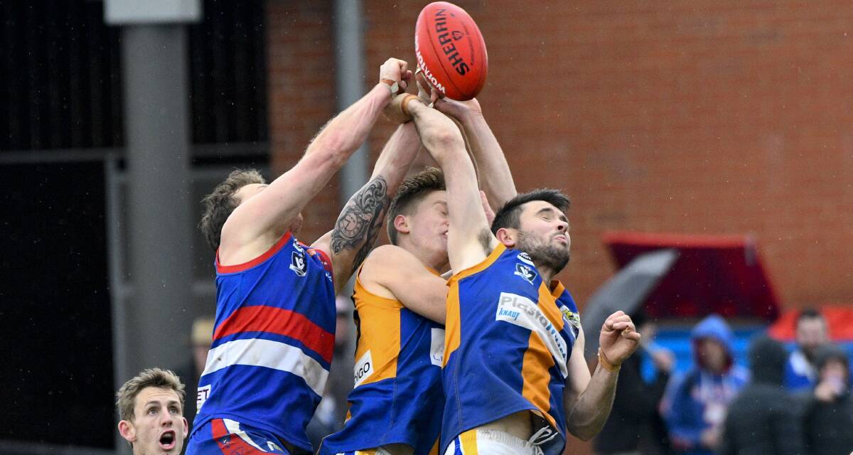 GUTSY: Golden Square's Jon Coe backs into the pack to spoil the ball. Picture: NONI HYETT