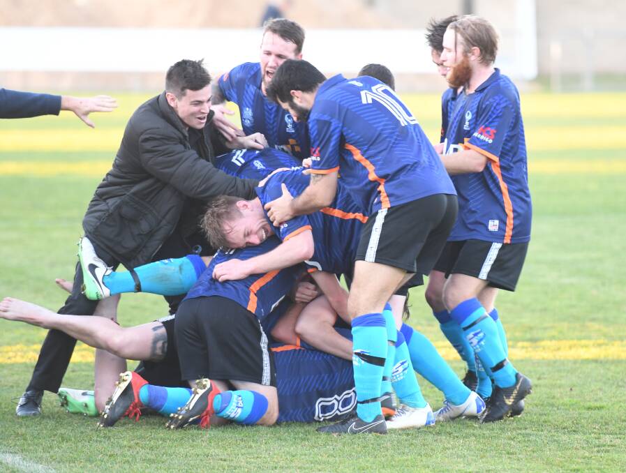Somewhere under the pile of Eaglehawk players is Brent Hamblin after he scored the match-winning goal on Sunday. Picture: ADAM BOURKE