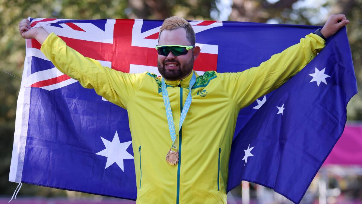 Aaron Wilson proudly displays the Australian flag after receiving his gold medal. Picture: GETTY IMAGES