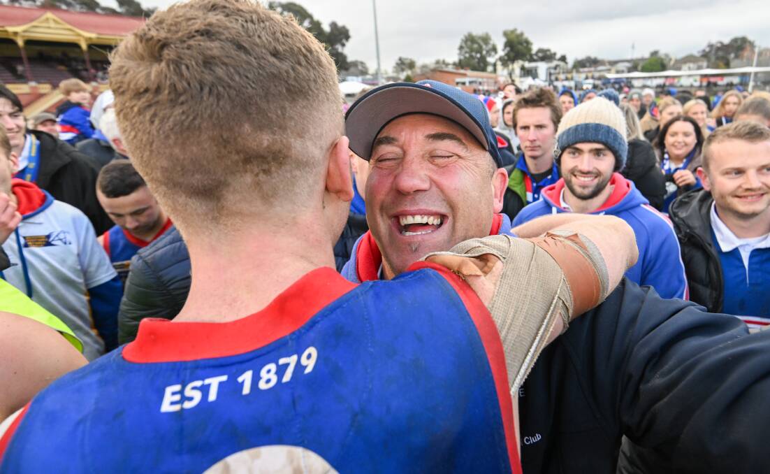 Gisborne coach Rob Waters embraces Jack Scanlon after the Bulldogs won the BFNL grand final. Picture by Darren Howe