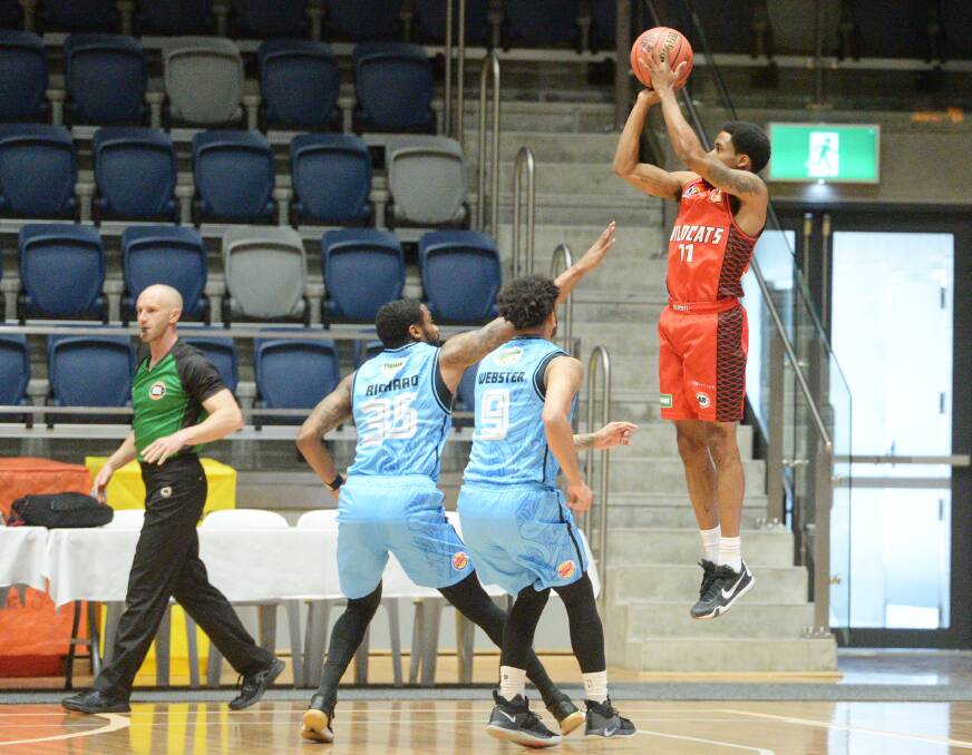 JUMP SHOT: Bryce Cotton shoots for three over two New Zealand opponents.