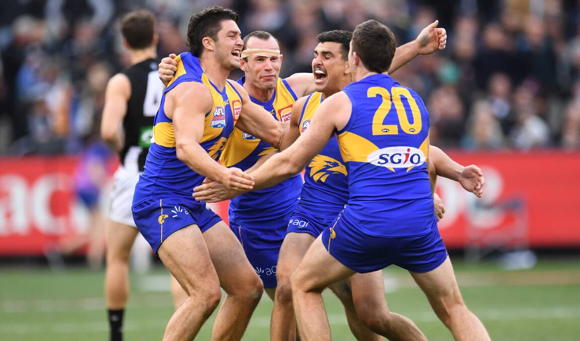 Tom Cole, third from right, is embraced by West Coast team-mates Tom Barrass, Shannon Hurn and Jeremy McGovern after the final siren of the grand final. Picture: FAIRFAX MEDIA