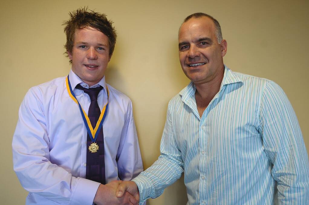 Lee Coghlan is presented with the 2009 Michelsen Medal by AFL great Greg Williams.