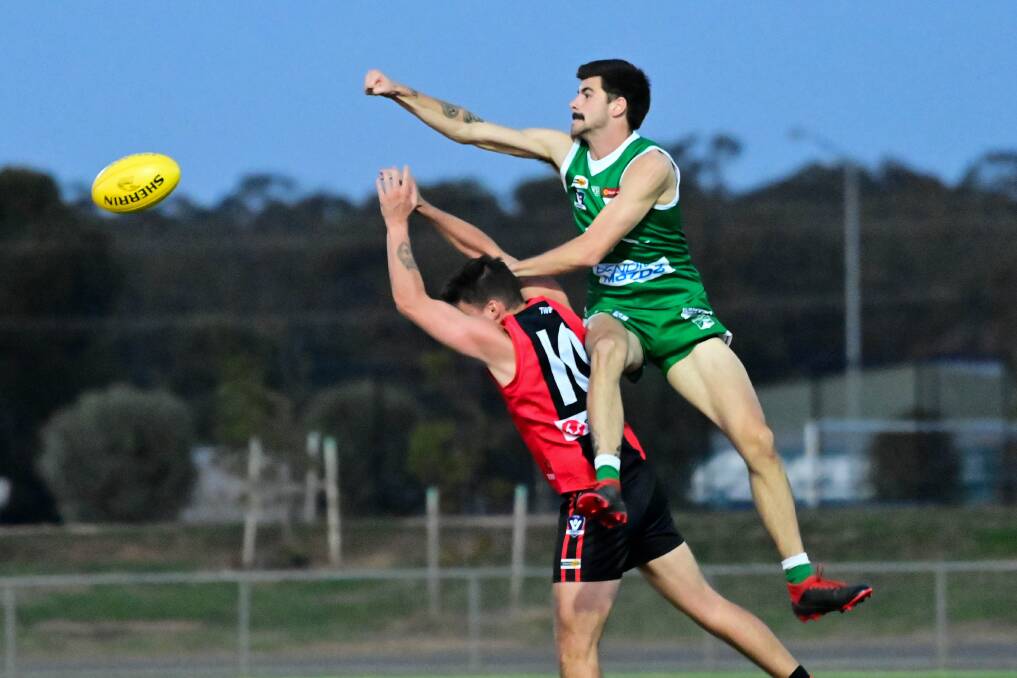 GOLDEN FIST: Kangaroo Flat defender Nick Keogh punches the ball clear against White Hills. Picture: BRENDAN McCARTHY