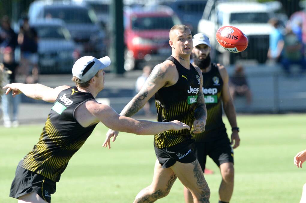 Dustin Martin handballs to Jack Riewoldt at the QEO. Picture: DARREN HOWE