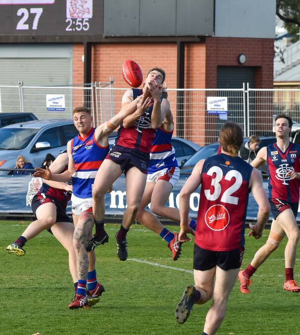 Lachlan Ross climbs high to attempt a mark against Gisborne.