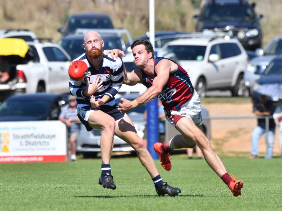 GRAND BATTLE: Shaun O'Farrell punches the ball clear of Storm star Lachlan Sharp. Picture: NONI HYETT