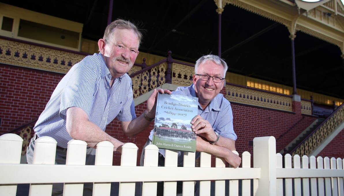 CRICKET FANS: John Harris and Darren Rodda with their new book Bendigo District Cricket Association 1894-2017. Picture: GLENN DANIELS