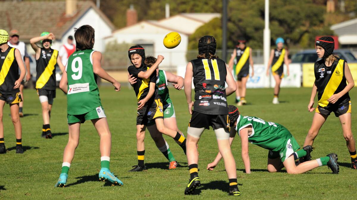 QUICK HANDS: Rochester Tigers' under-14s in action against Kangaroo Flat in the BJFL. Picture: ADAM BOURKE