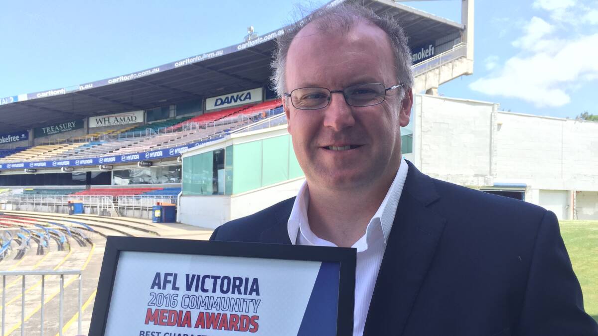 WINNERS ARE GRINNERS: Bendigo Advertiser photographer Darren Howe with his AFL Victoria  Community Media Award trophy.