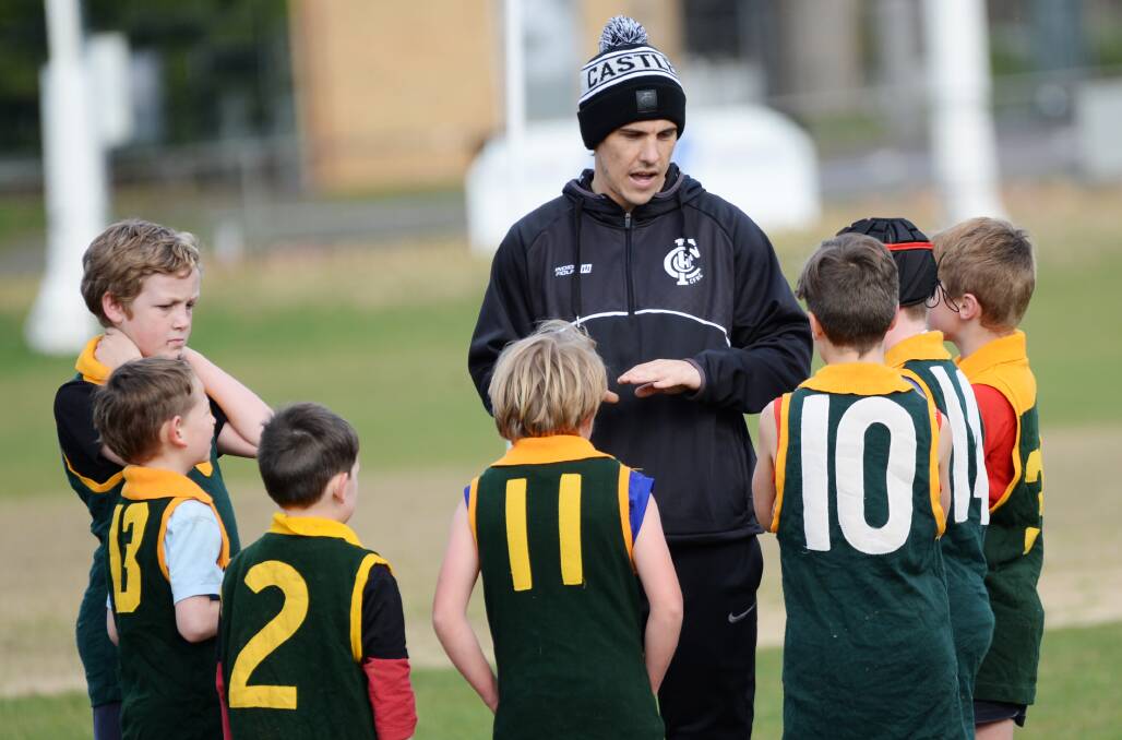 Angus Monfries talks with young footballers at the Castlemaine FNC school holiday program. Picture: DARREN HOWE