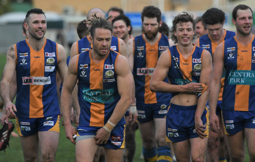 ALL SMILES: Golden Square skipper Jack Geary leads the Bulldogs off the ground after their big win.