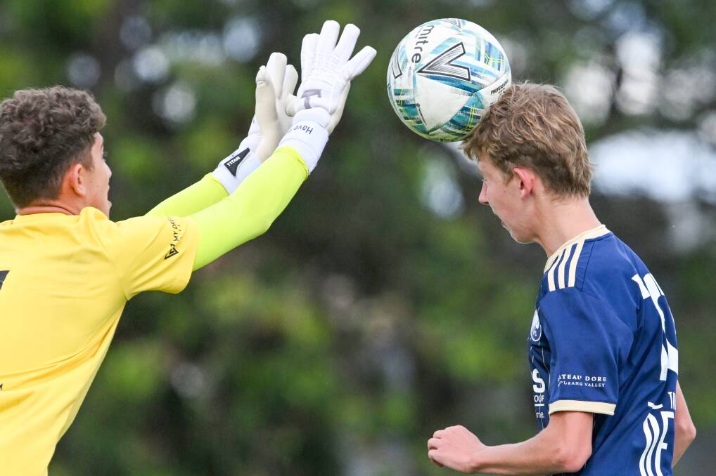 Bendigo City under-16 striker Kai Thomas tries to head the ball clear of Eltham's goalkeeper. Picture by Darren Howe