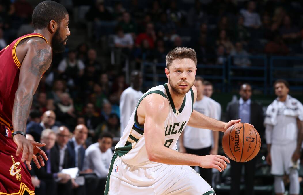LAST LAUGH: Matthew Dellavedova takes on his former team-mate Kyrie Irving in Milwaukee. Picture: GETTY IMAGES