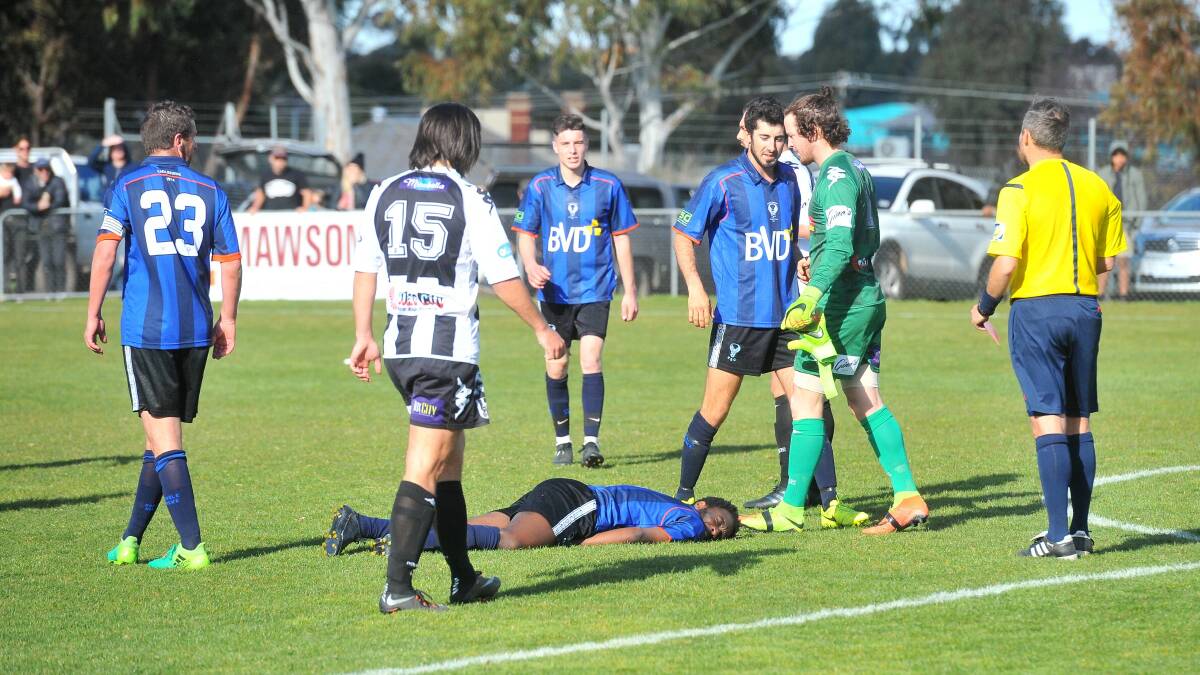 Eaglehawk's Andre Latt on the ground after colliding with Shepparton South goalkeeper Nick Moroni. Latt played out the game, while Moroni was shown a red card. Picture: ADAM BOURKE