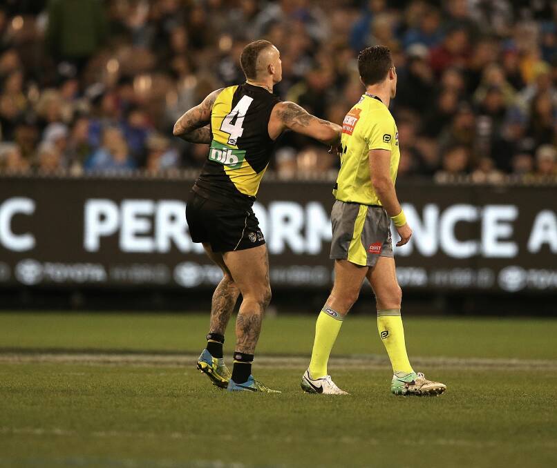 Dustin Martin makes contact with umpire Jacob Mollison. Picture: WAYNE LUDBEY, THE AGE