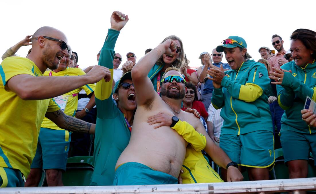 HISTORY-MAKER: A shirtless Aaron Wilson is emabraced by his Jackaroo team-mates after he won the Commonwealth Games gold medal. Picture: GETTY IMAGES