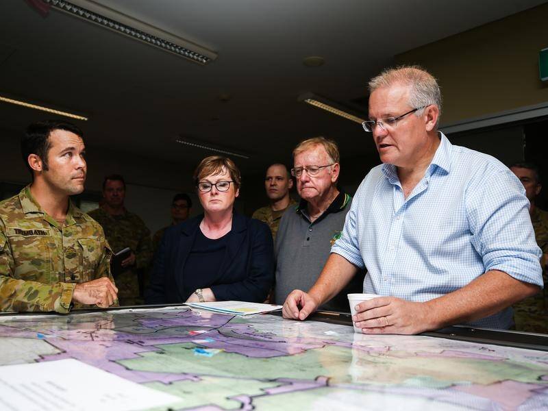 PM Scott Morrison (right) has toured homes and businesses damaged by floods in north Queensland.