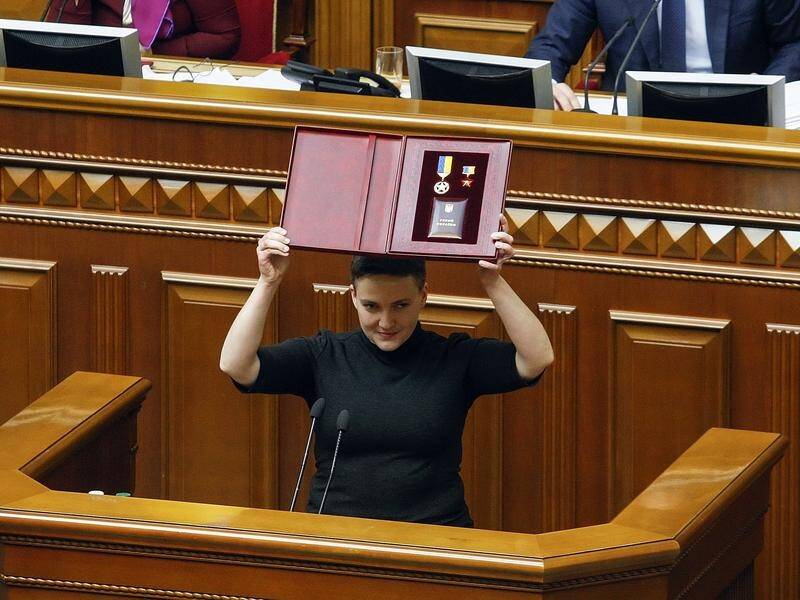 Nadiya Savchenko, holding her Star of the Hero of Ukraine, is accused of having fake COVID-19 docs.