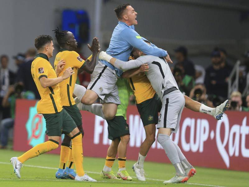 Goalkeeper Andrew Redmayne (r) is swamped after helping the Socceroos qualify for the World Cup.