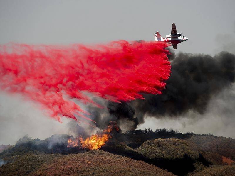 Fire retardant is dropped onto a fire burning near Lakeport, California, as thousands are evacuated.