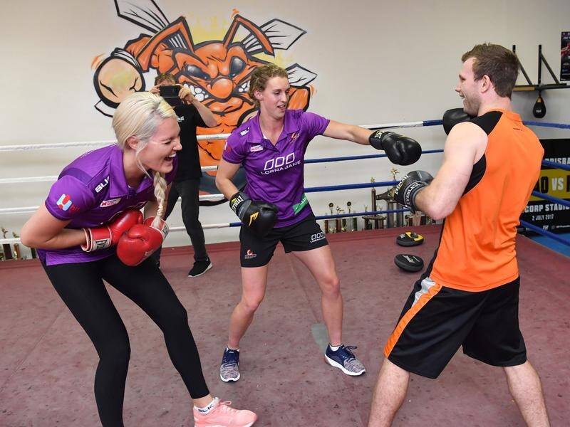 Jeff Horn squares off with Queensland Firebirds players Gretel Tippett (l) and Gabi Simpson.