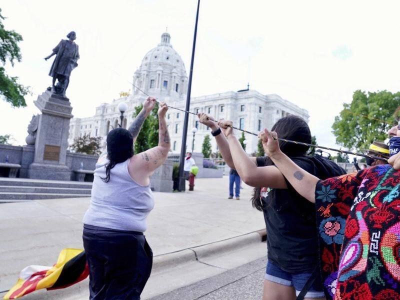 Protesters pull down a statue of Christopher Columbus in St Paul, Minnesota.