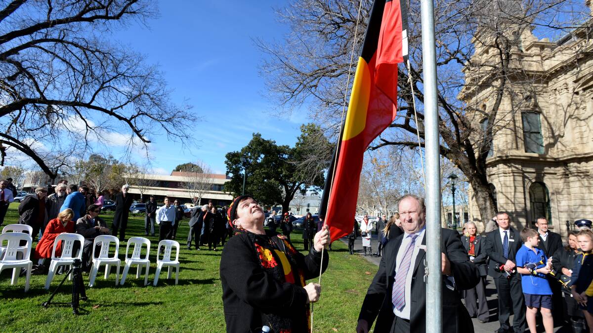Aunty Lyn Warren and Bendigo mayor Barry Lyons raise the Aboriginal flag during the launch of NAIDOC Week. Picture: JIM ALDERSEY